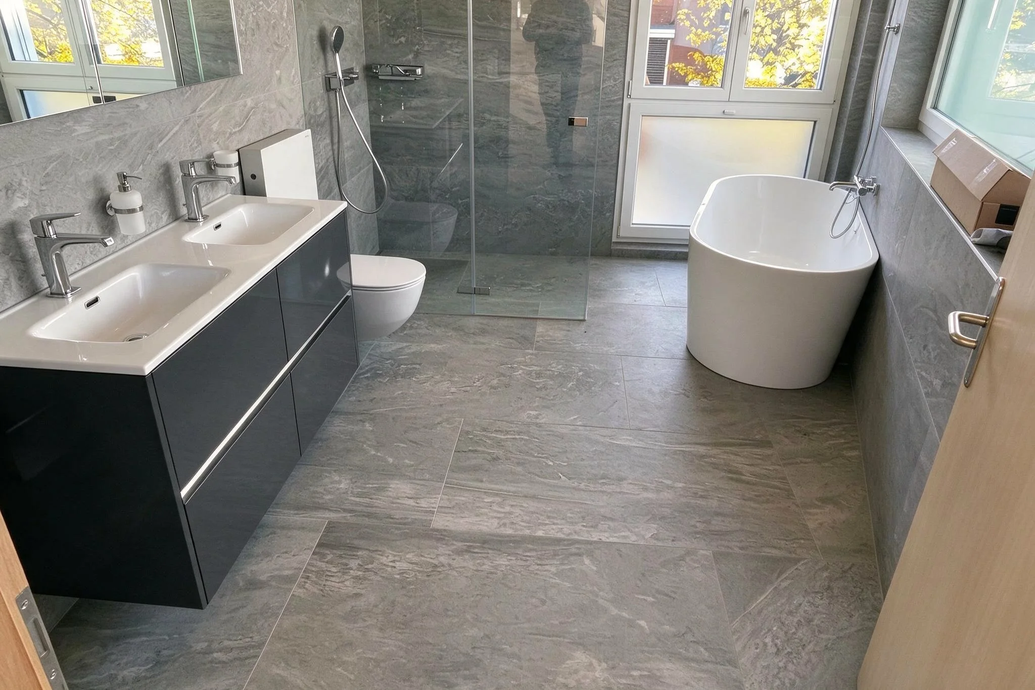 Modernes Badezimmer mit hochwertigen Fliesen an Wand und Boden